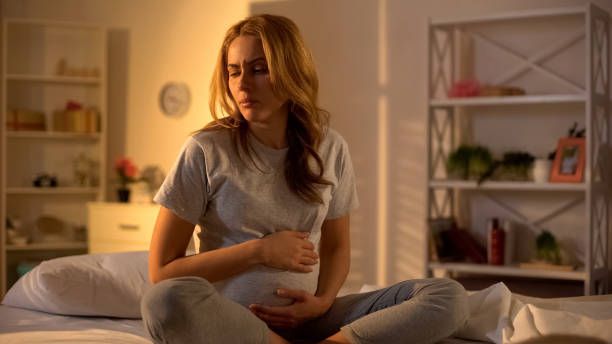Pregnant woman consulting doctor for high-risk pregnancy monitoring and care