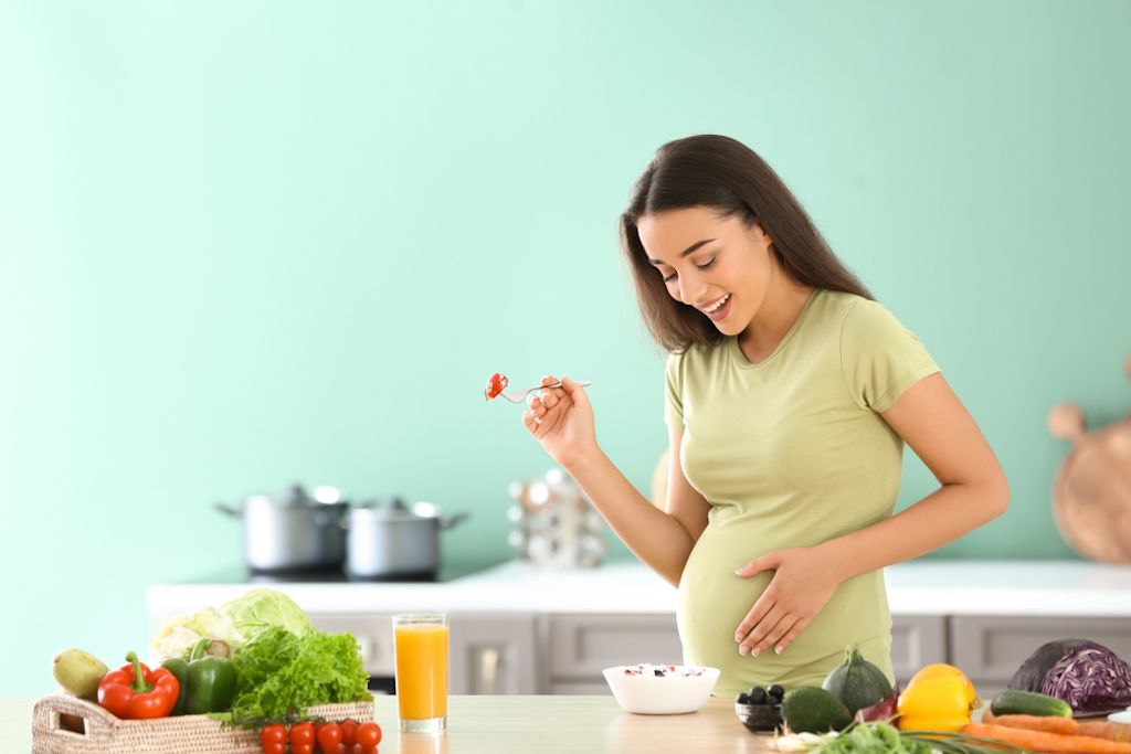 Happy pregnant woman holding her belly showing a healthy and positive pregnancy journey